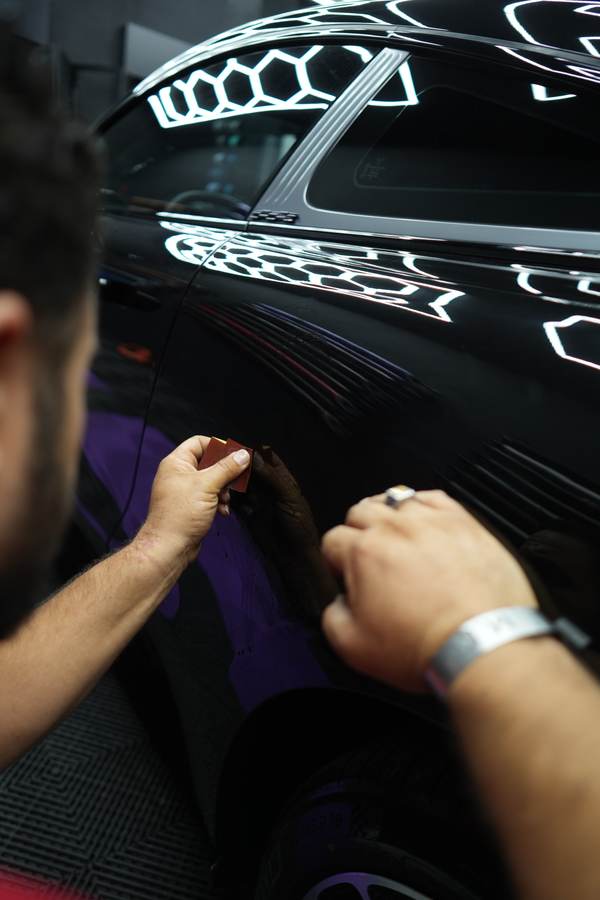 Hands laying vinyl on a panel